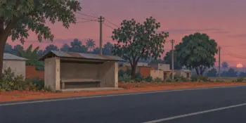 An empty bus stand shelter on a highway at dusk