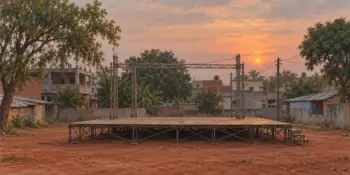 An empty open-air stage with bare scaffolding at sunset