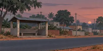 An empty bus stand shelter on a highway at dusk