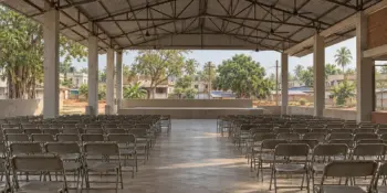 A wide empty hall with rows of folding chairs