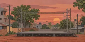 An empty open-air stage with bare scaffolding at sunset