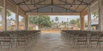 A wide empty hall with rows of folding chairs